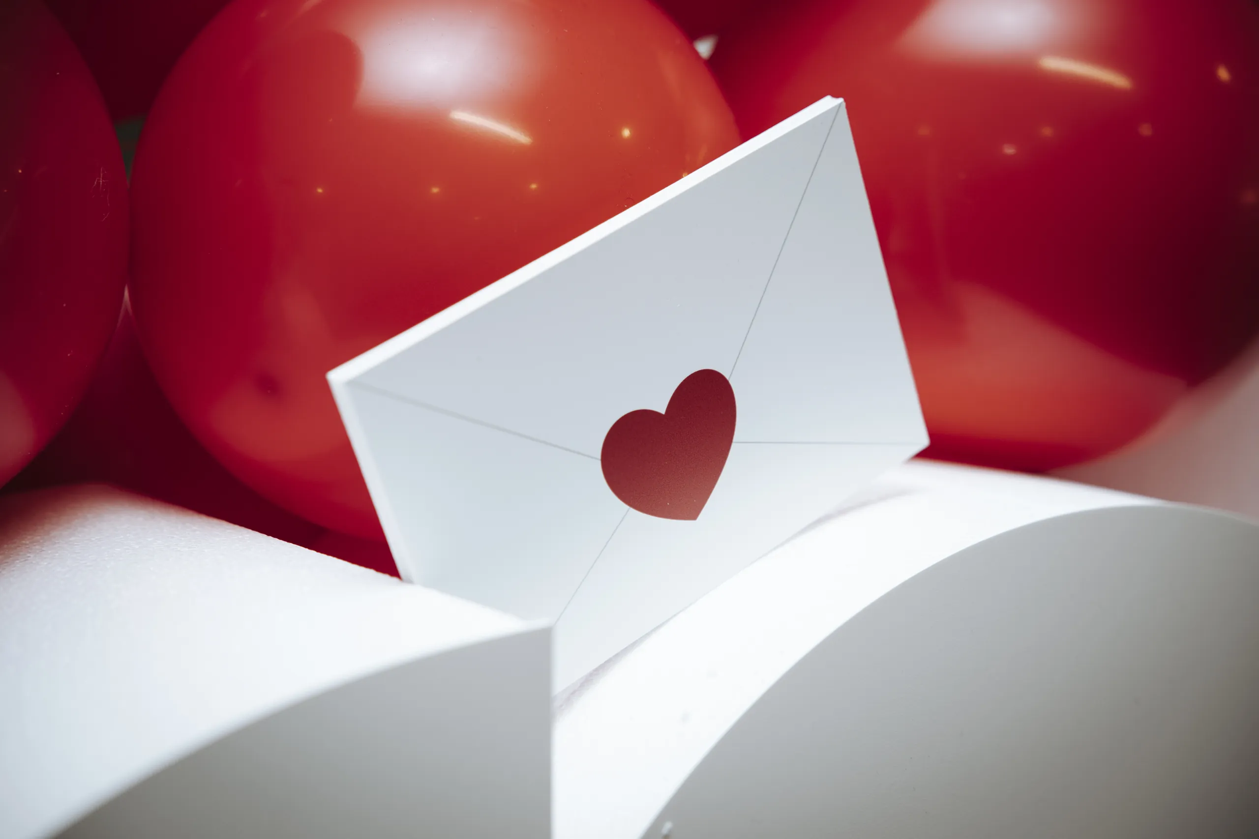Activation Saint-Valentin Brother - enveloppe blanche au cœur rouge entre les ballons par Event Machine
