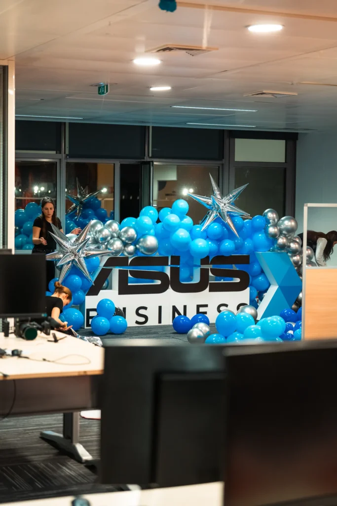 Christmas Party Asus - arche de ballons bleus et argentés autour du logo Asus Business dans l'open space par Event Machine