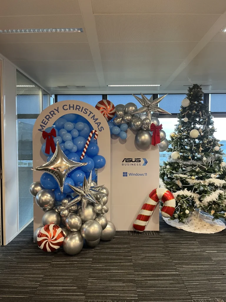 Christmas Party Asus - photocall Merry Christmas en ballons bleus et argentés à côté d'un sapin de Noël par Event Machine