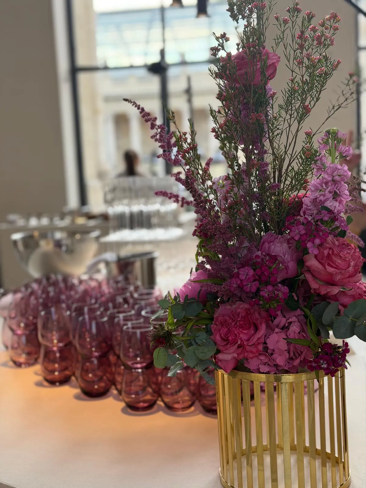 Scénographie CNCPI - bouquet rose en vase doré et verres roses sur le bar par Event Machine