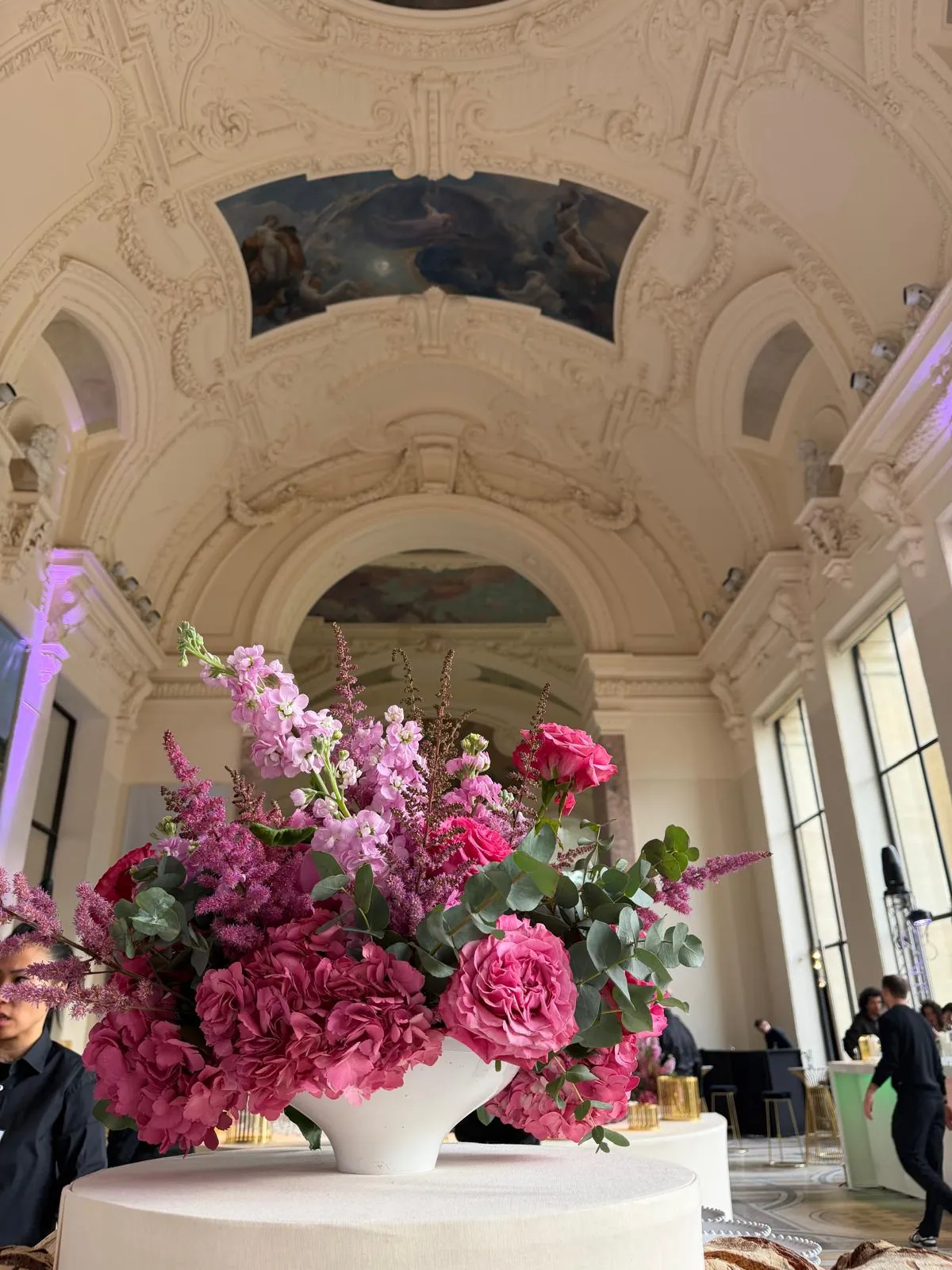 Scénographie CNCPI - composition florale rose sur une table ronde dans la galerie par Event Machine