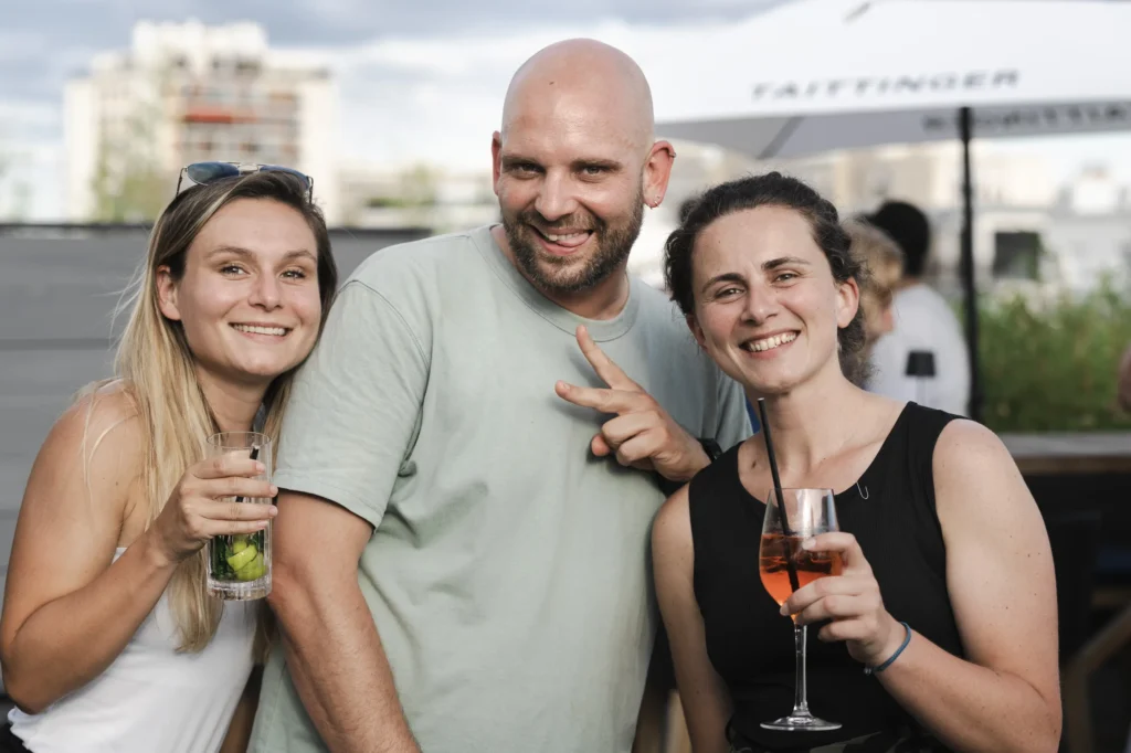 Séminaire Les Vidéopreneurs - trois participants souriants posant verre à la main sur le rooftop par Event Machine