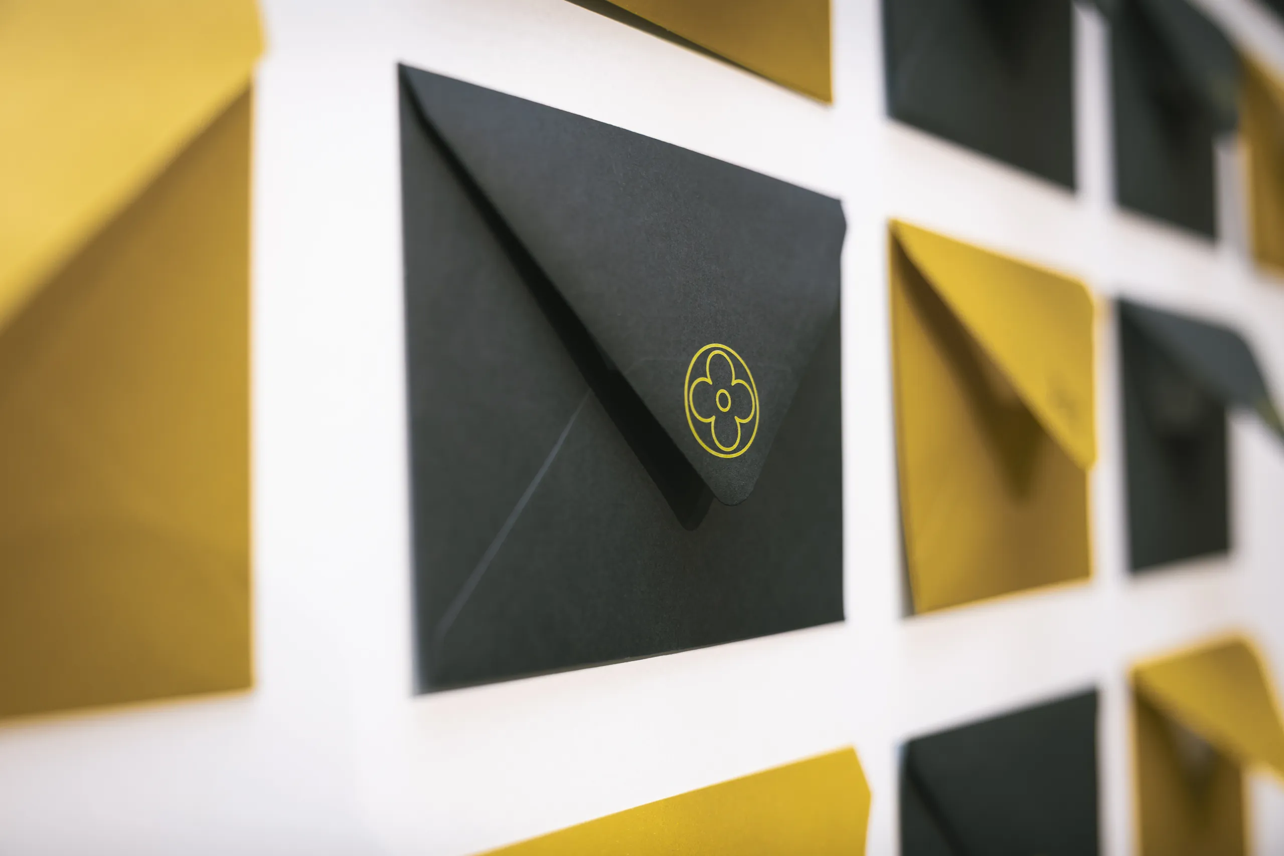 Soirée des vœux Louis Vuitton - détail d'une enveloppe noire au motif fleur doré par Event Machine