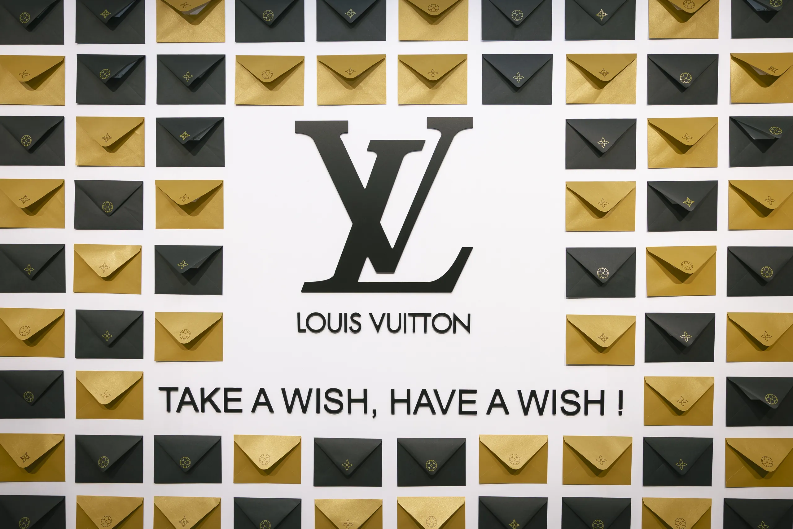 Soirée des vœux Louis Vuitton - panneau central du mur des vœux encadré d'enveloppes or et noires par Event Machine