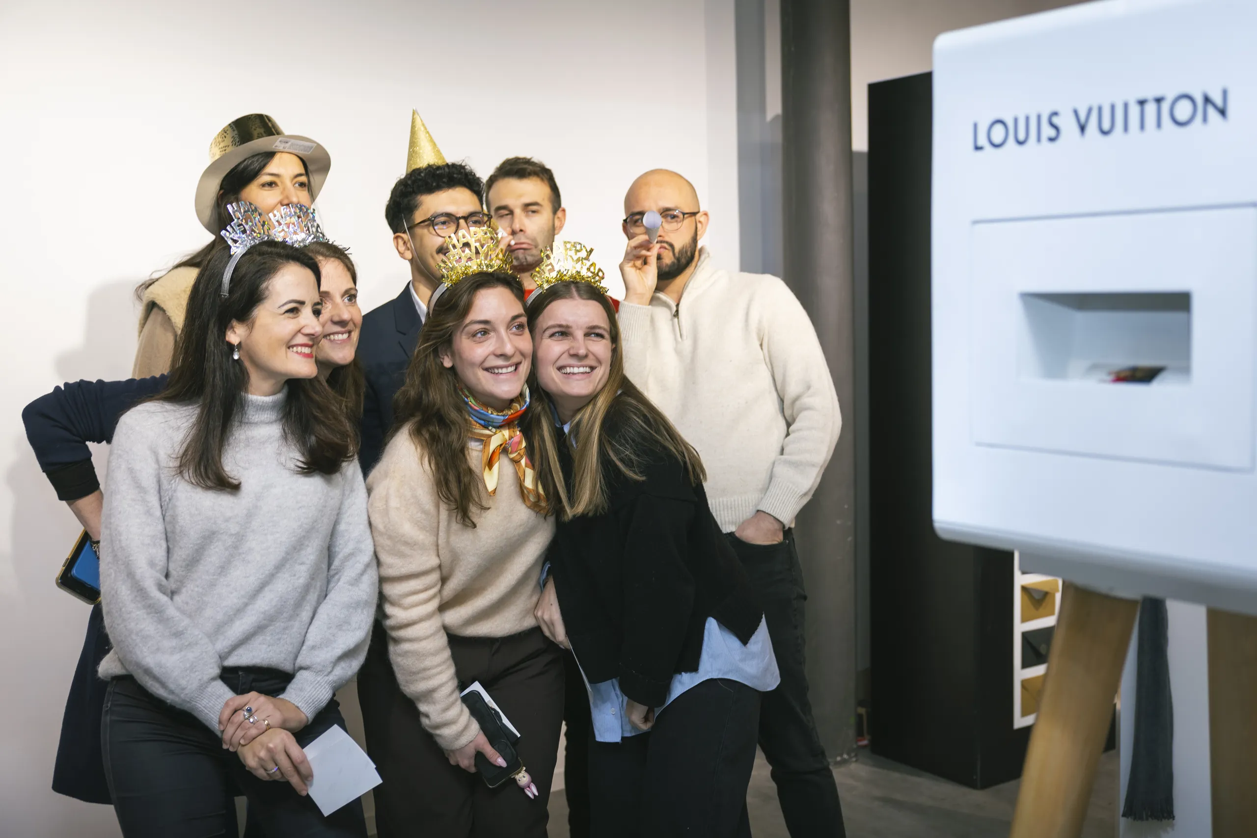 Soirée des vœux Louis Vuitton - invités posant avec couronnes dorées et accessoires de fête par Event Machine