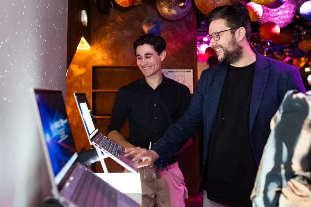 Soirée de lancement Microsoft - deux invités découvrant les nouveaux ordinateurs portables sur un stand par Event Machine