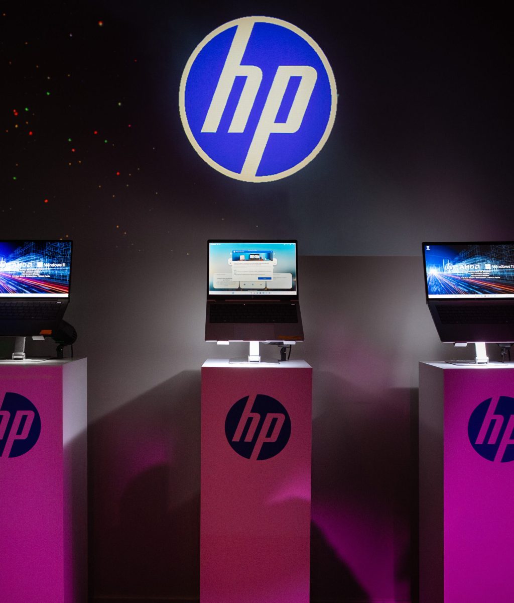 Lancement de produit HP organisé par Event Machine : ordinateurs portables exposés sur socles roses avec logo HP rétroéclairé